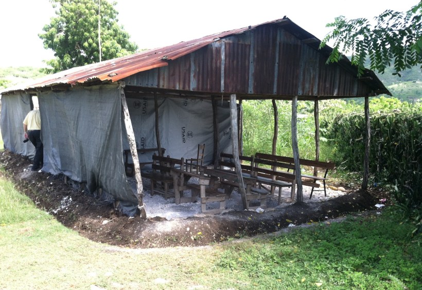 This rural school holds high school classes in this structure. Classrooms are separated by tarps.