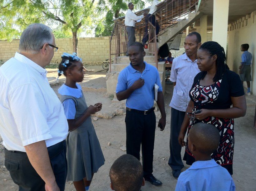 Adline and Joel questioning a student about her brother's school attendance. "He doesn't have any shoes." (The money was quickly provided for that need!)