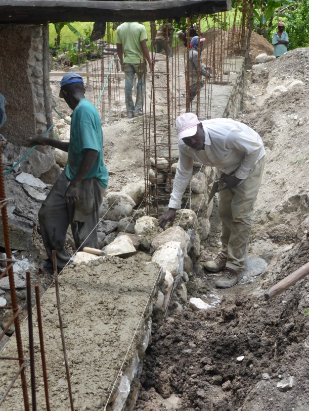 Chiseling and piling rocks all day in the hot sun to create the foundation walls!