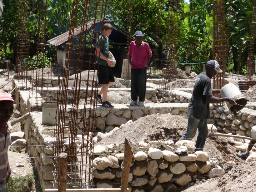 Experienced enough at roof construction, Grant tries his hand at foundation work.