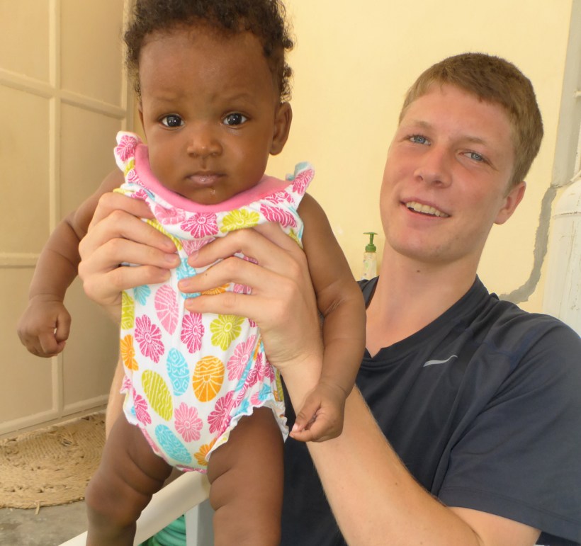 Grant, taking a break from school, to help babysit Bessakina, our cook's baby!