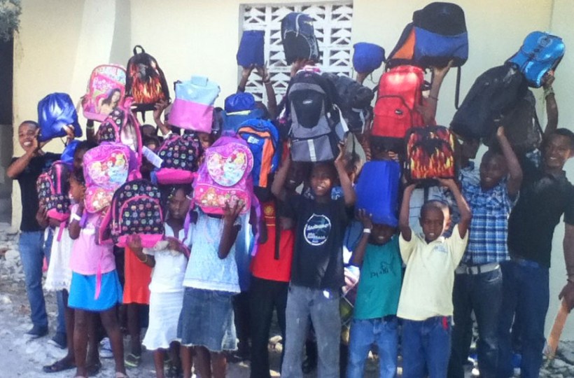 Before they left for home, the kids are showing off the book bags they won!