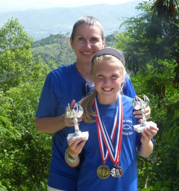 Grace holding her track and field day awards with Mrs. Ferris.