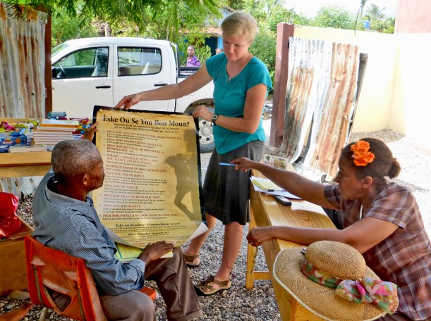 Marie Lucie is reviewing the poster with a pastor!